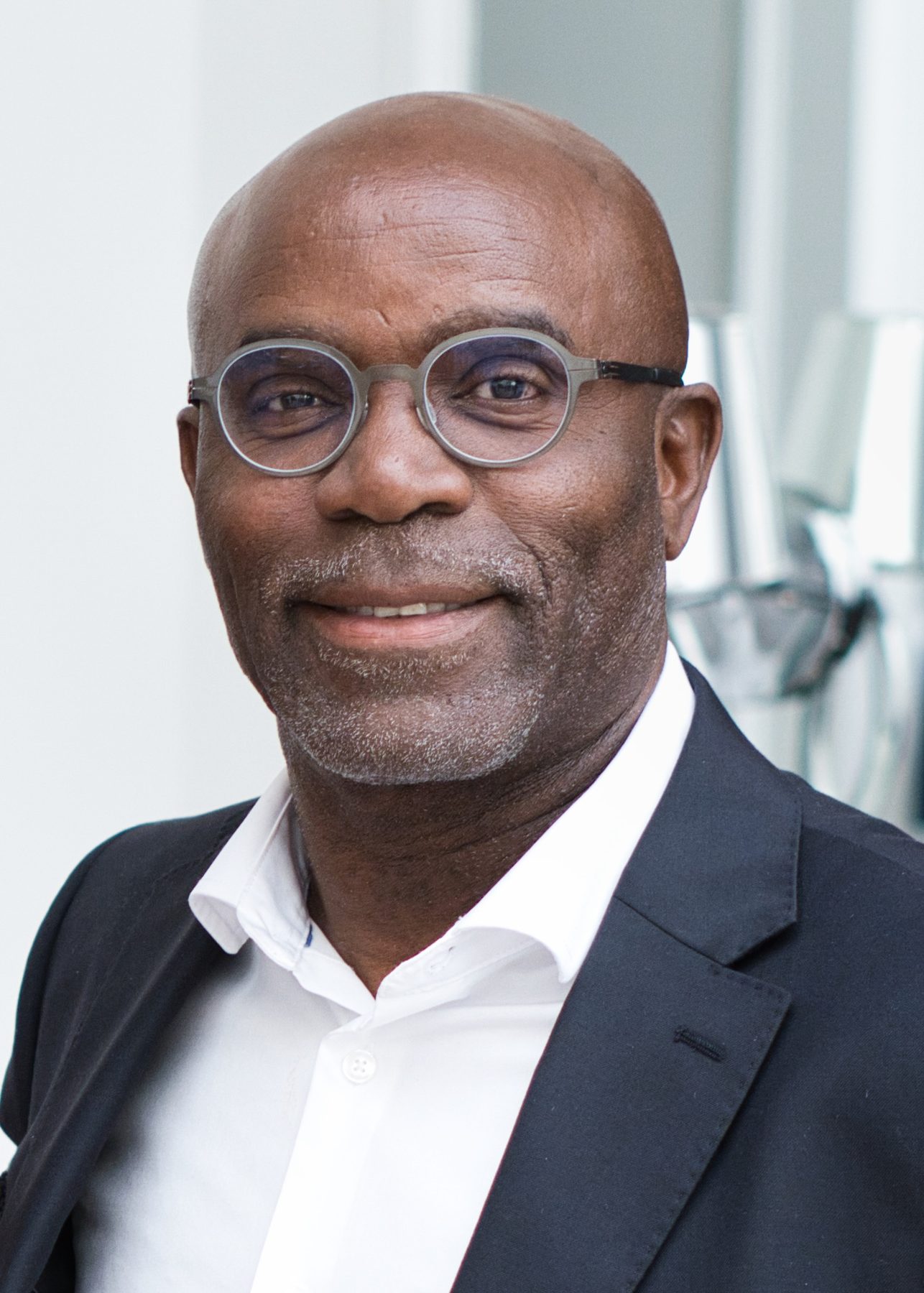 Corporate headshot of a smiling man in a navy suit
