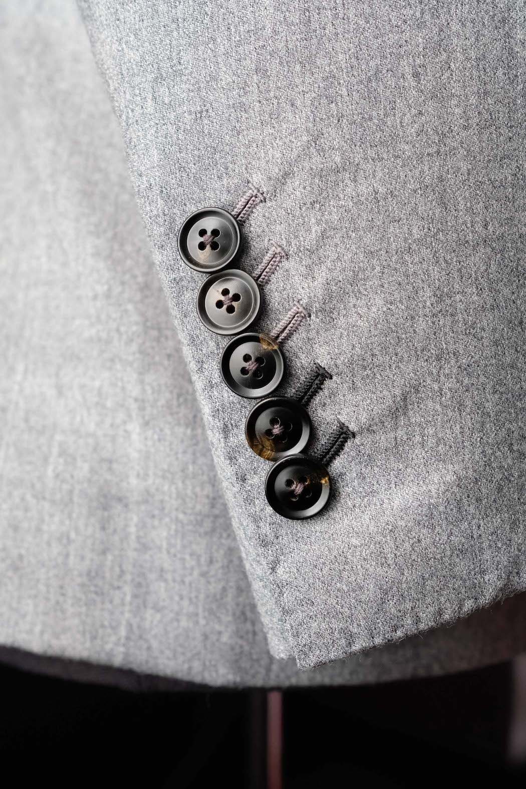 Close up of horn buttons on a grey flannel sleeve